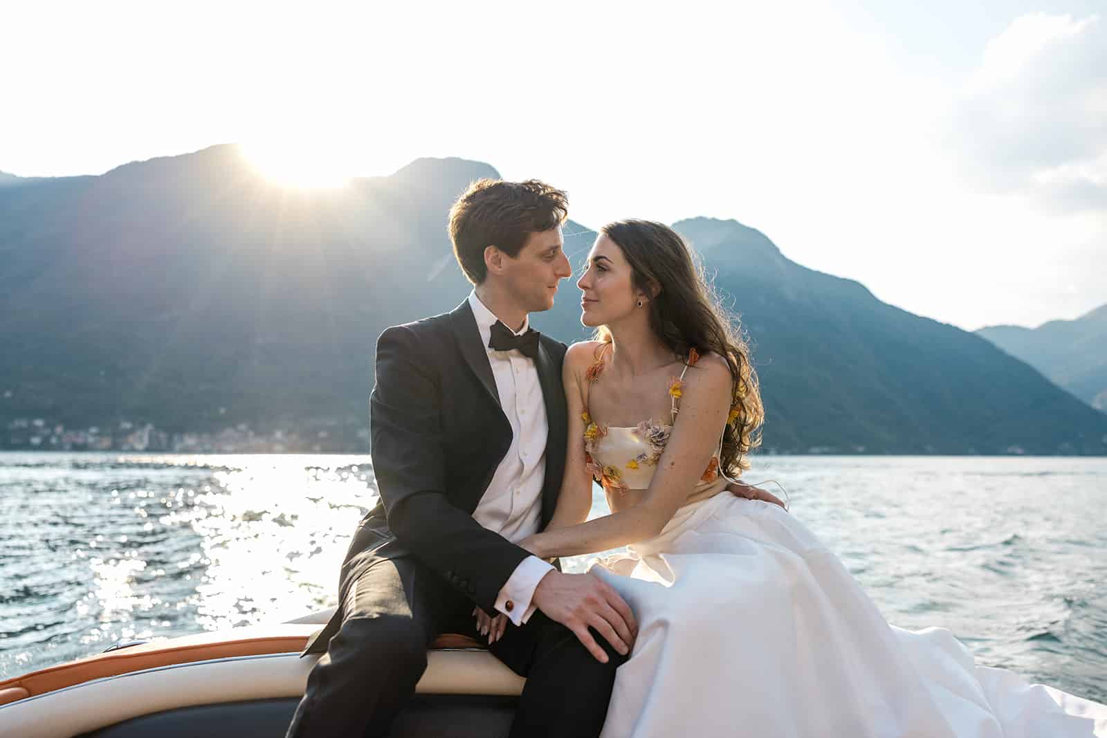 Bride and groom on a classic boat in Lake Como, Italy on their wedding day, captured by a destination photographer with the appropriate wedding photography equipment