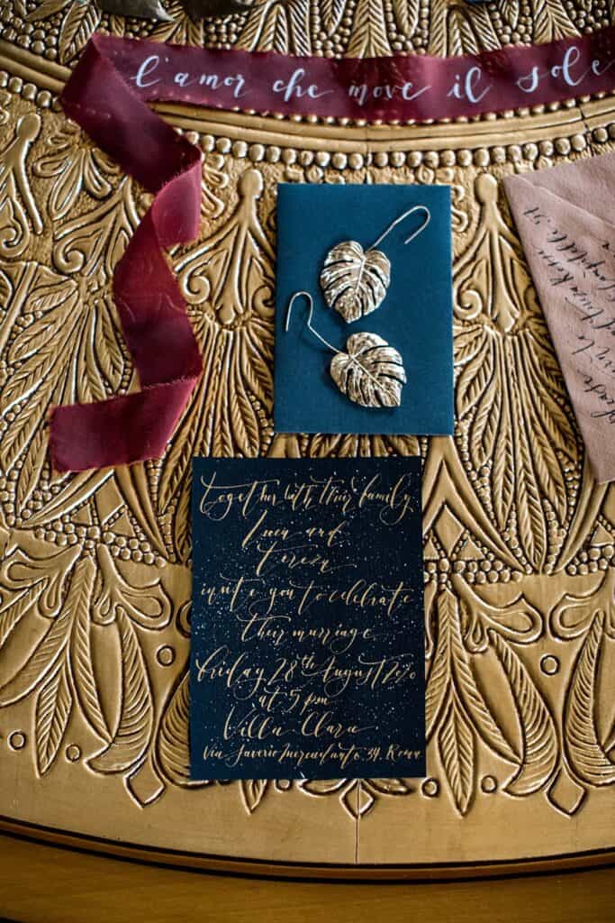 Gold, merlot, navy wedding invitation flat lay photo