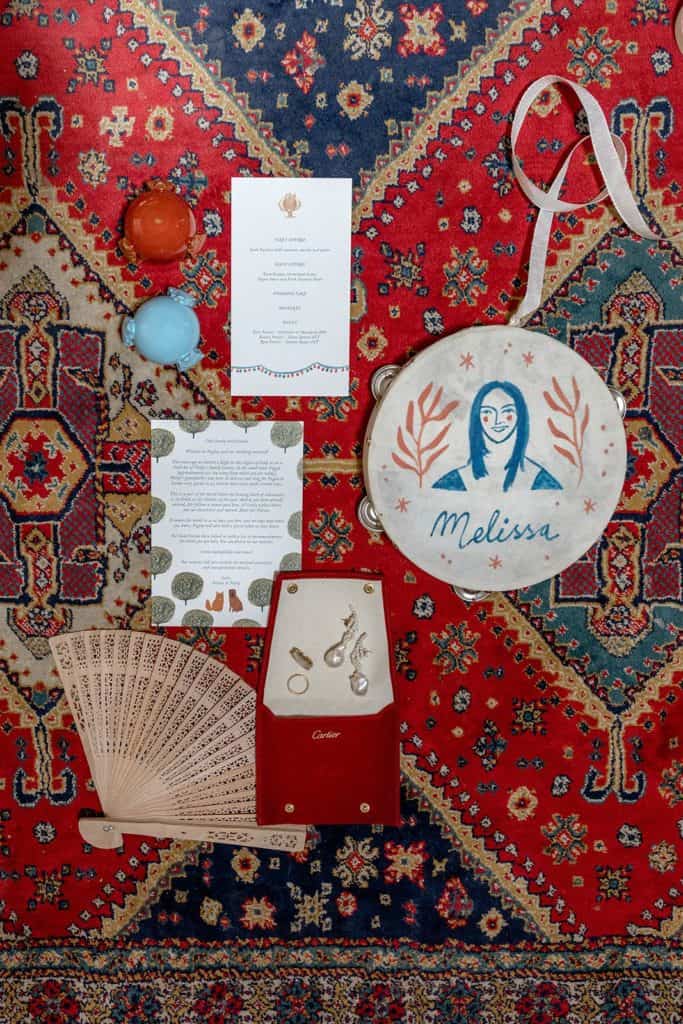 Masseria Potenti wedding invitation suite flat lay featuring unique keepsakes like hand painted tambourines