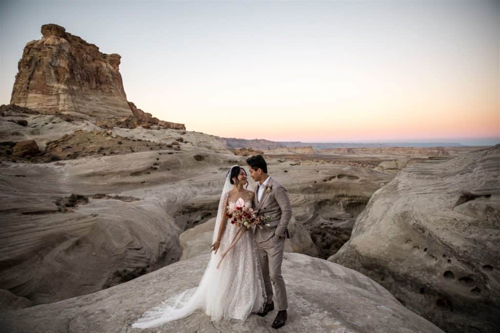 Man and woman stand together for bridal portraits after getting married at Amangiri, Utah