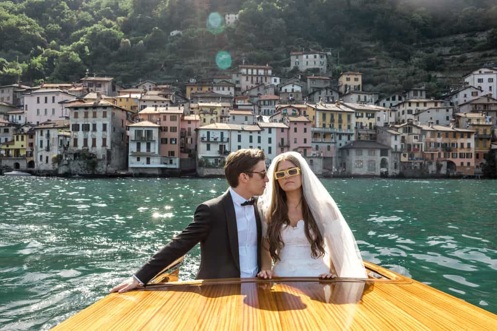 Groom looks at bride during Lake Como boat ride, a photo submitted to wedding blogs to be featured