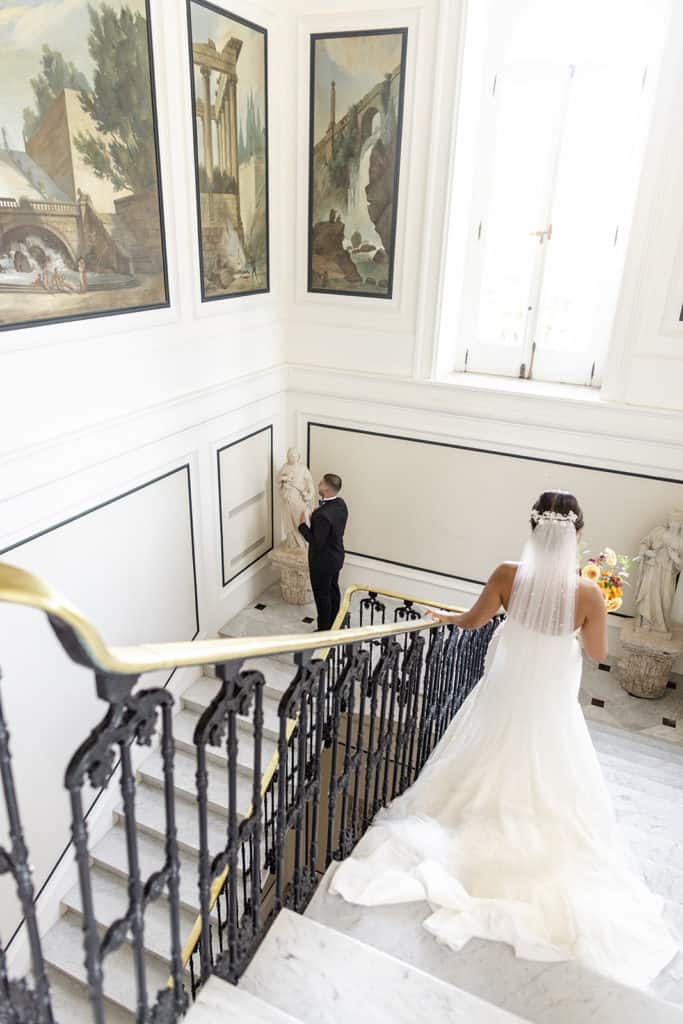 Bride walks downstairs to groom for first look on wedding day