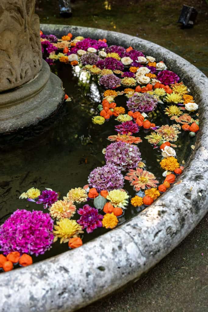 Detail photo of flowers in a water fountain serves as an example of photos to be featured in the best wedding blogs