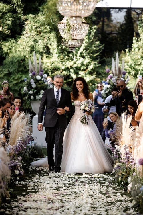 Bride and father walk down the wedding ceremony aisle at a luxury wedding