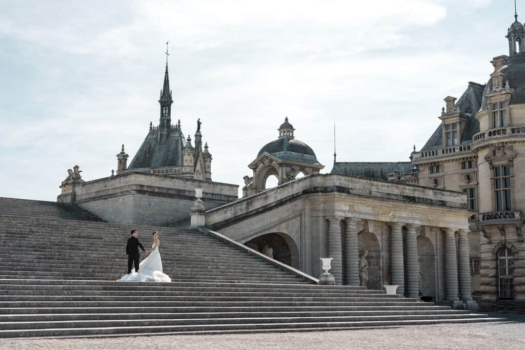 Bride and groom epic staircase at Chateau de Chantilly, a curated photo after learning tips for blogging for wedding photographers