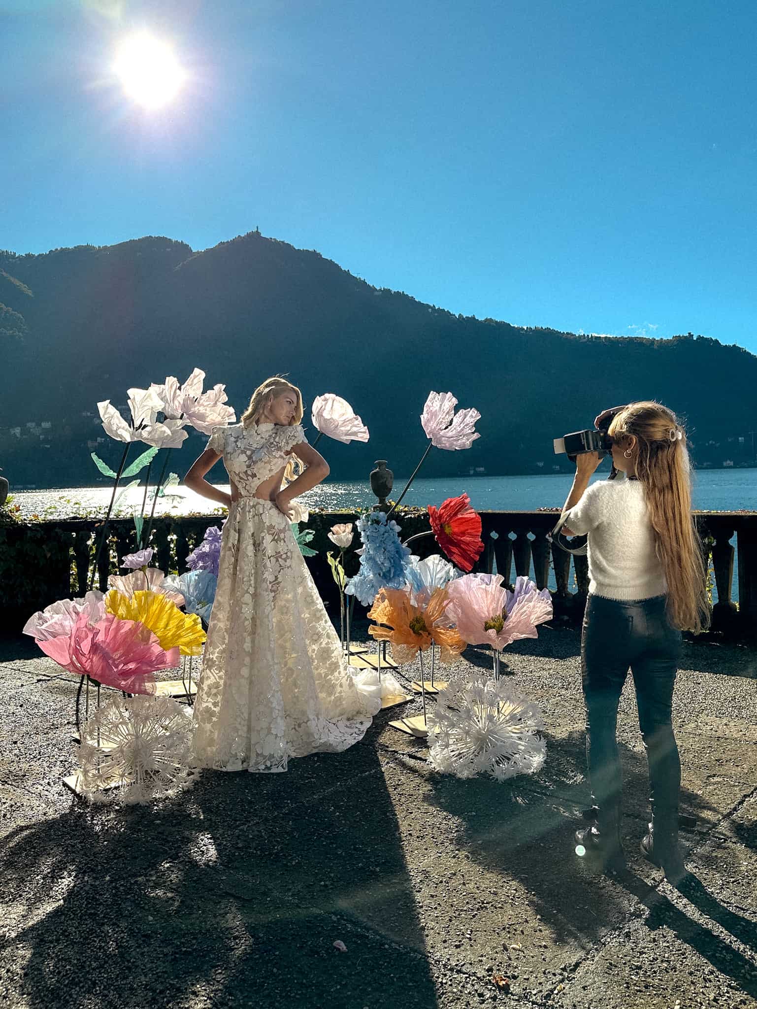 Lilly Red photographer photographing on top of darsena with model in a wedding dress with large gigantic flowers